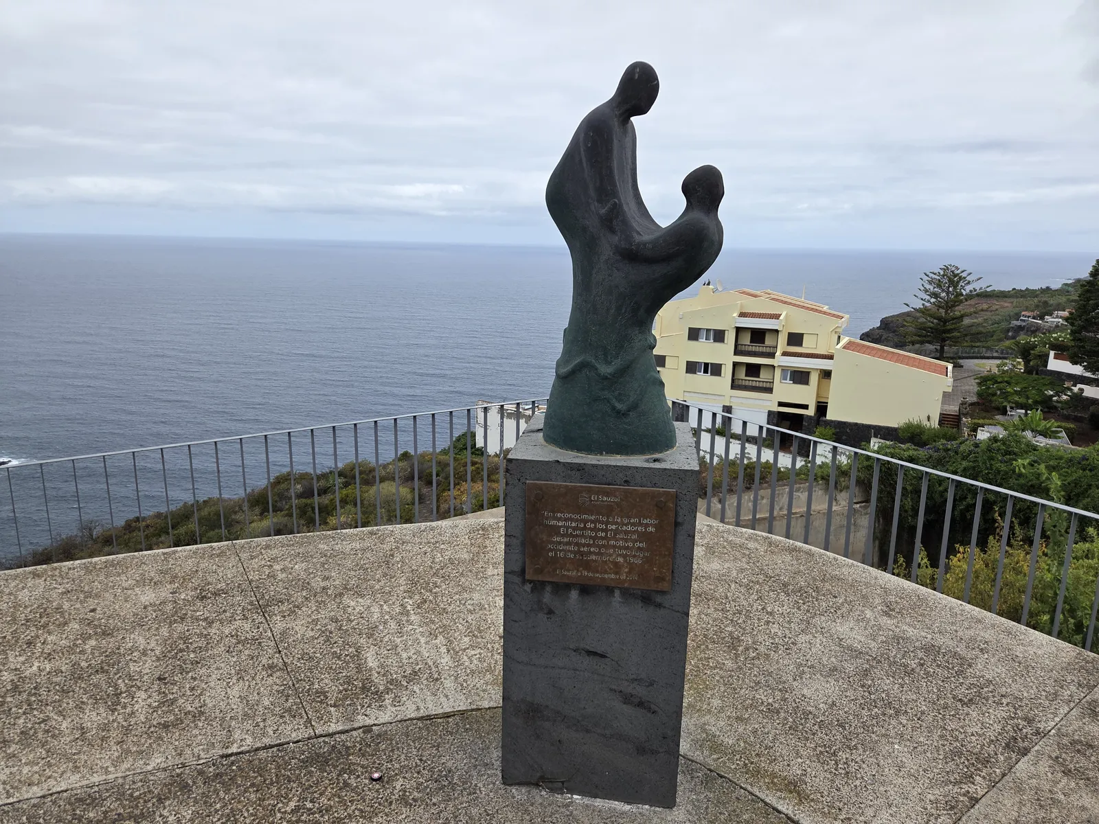 Sculpture of two figures on a stone pedestal overlooking the Atlantic at Mirador de Las Breñas