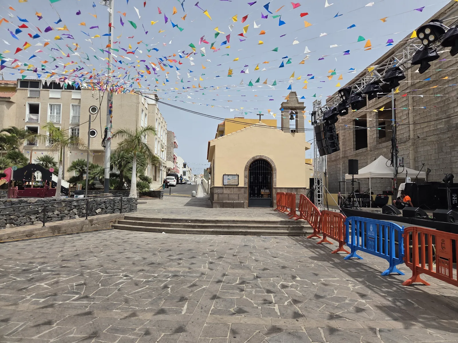 Yellow-fronted San Blas chapel beside a square decorated with colourful bunting in Los Abrigos