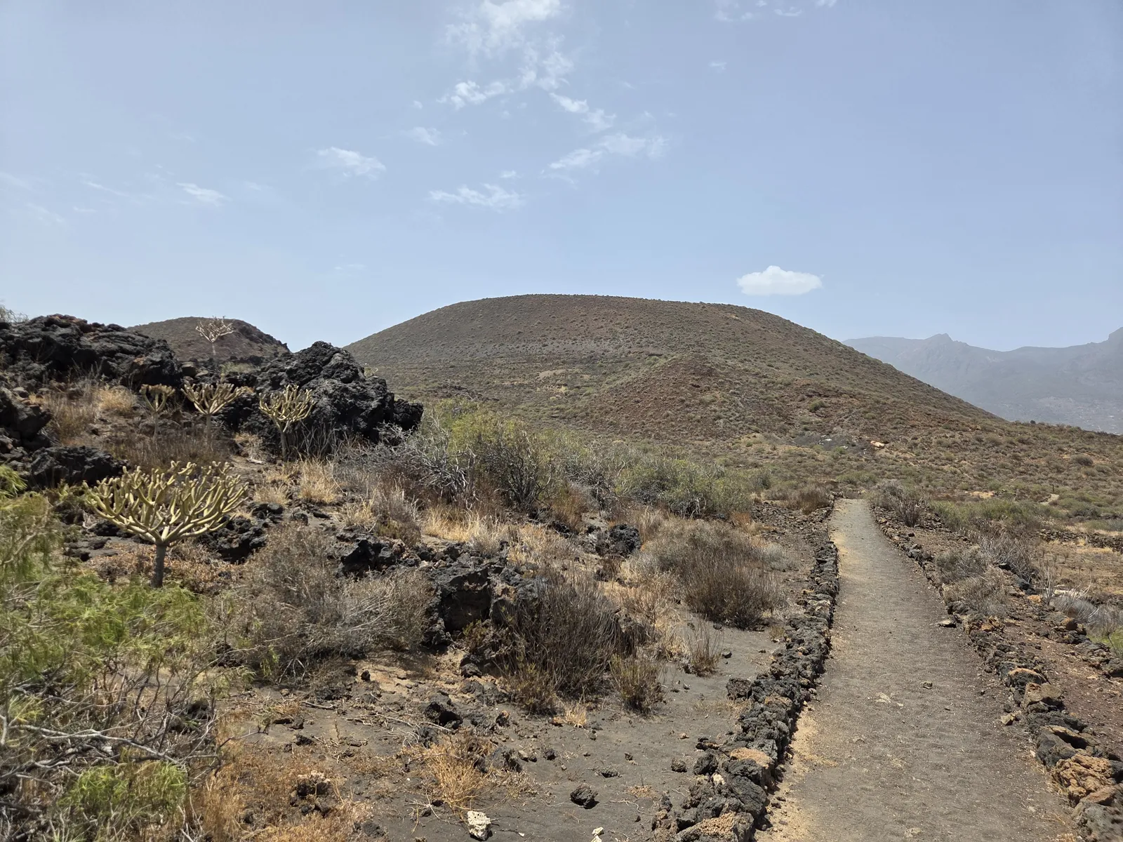 Stone-edged path crossing volcanic terrain towards Montaña Grande in Malpaís de Güímar