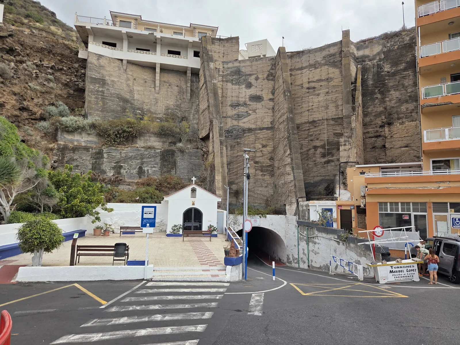 Beach access tunnel beside a small white chapel and a bus stop in Mesa del Mar