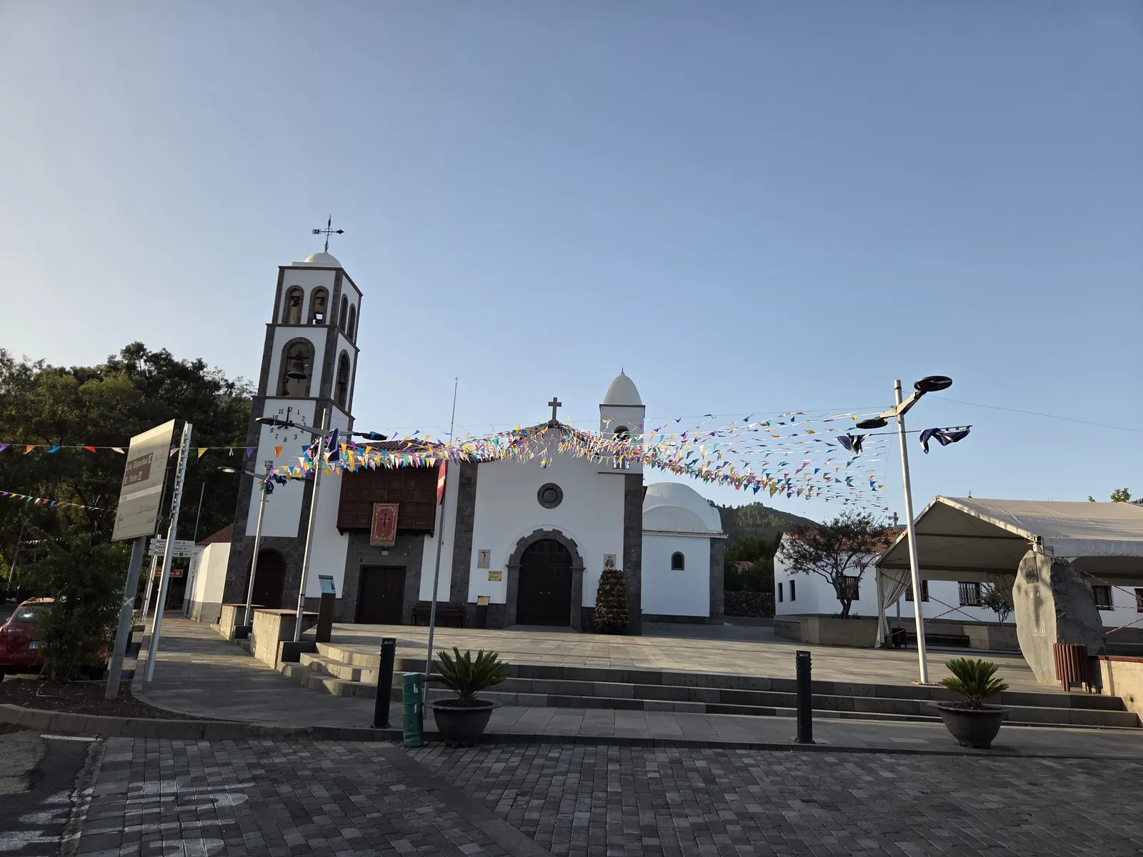 White façade and bell tower of San Fernando Rey church facing the square in Santiago del Teide
